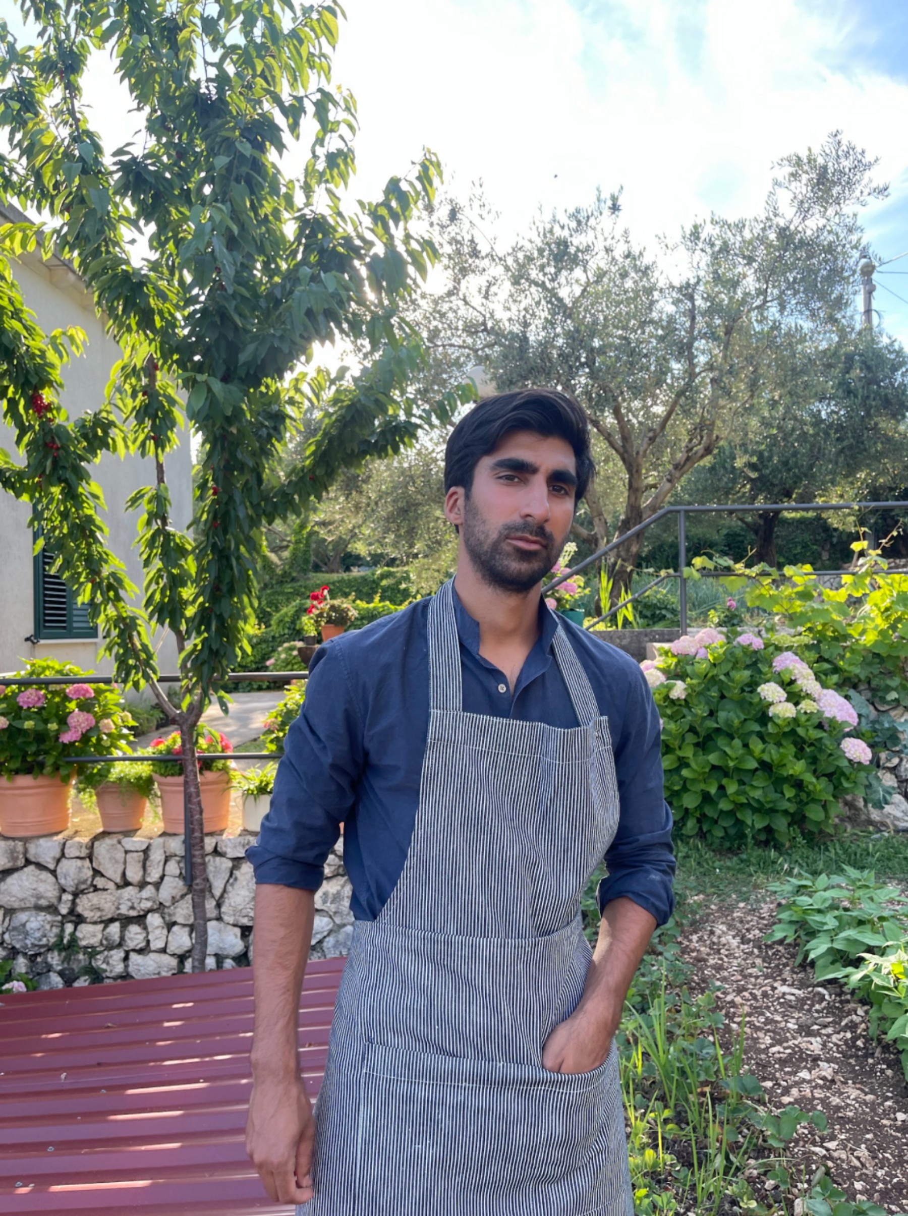 Brij wearing an apron in a garden