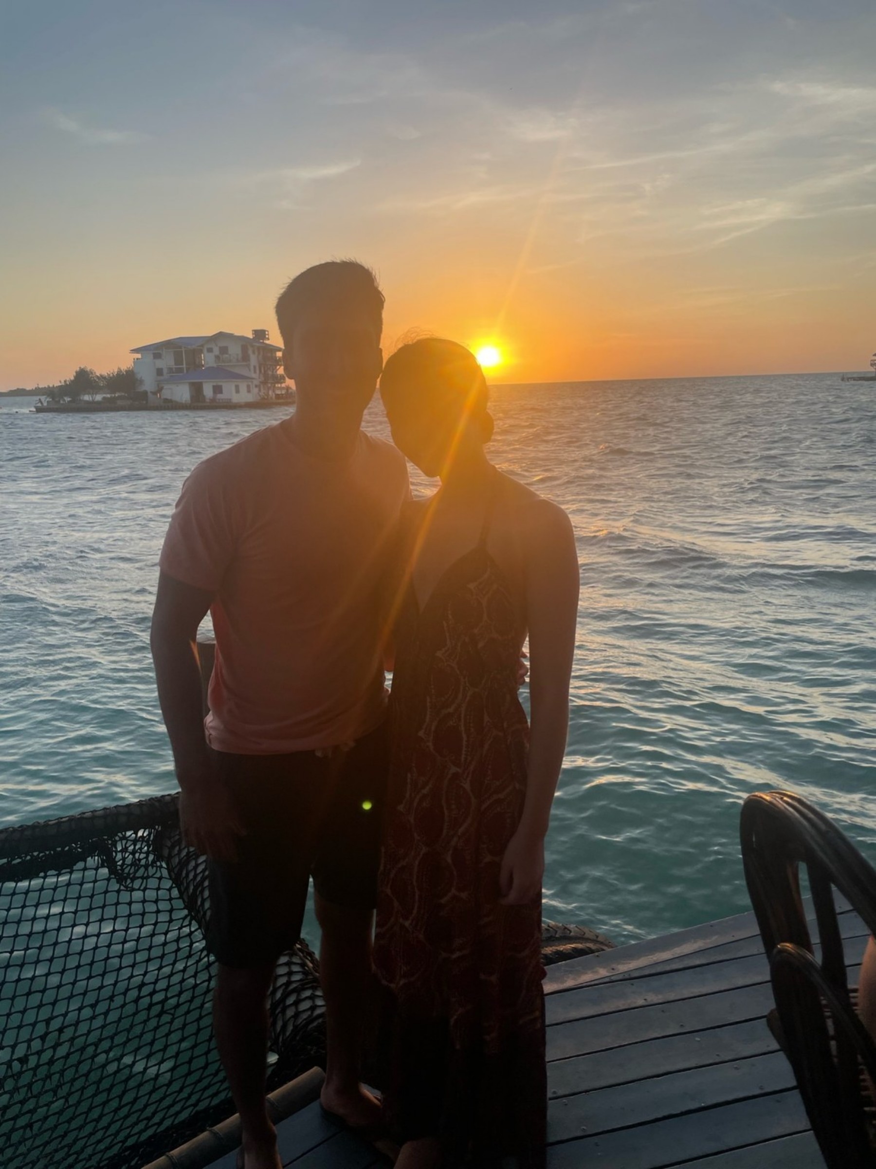 Cate and Brij beside the ocean at sunset in Colombia